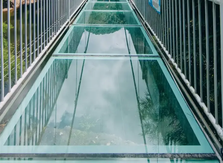 Suspension bridge with colorful flags over a mountain valley