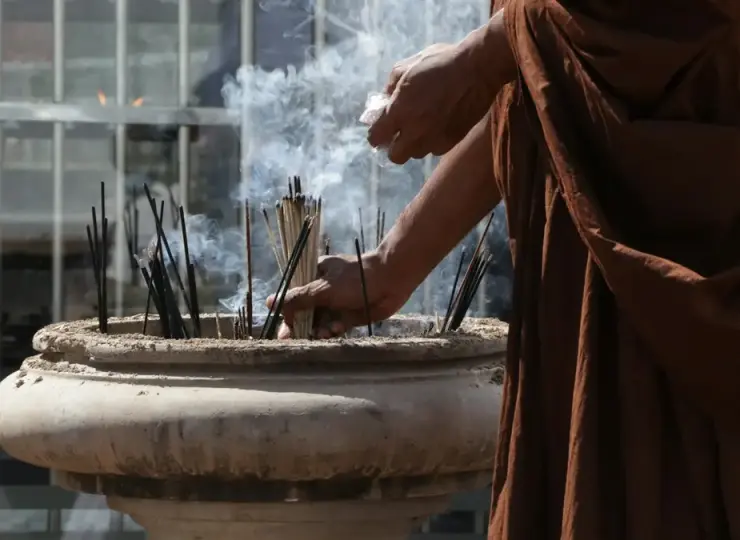 A person pouring water into a temple fountain