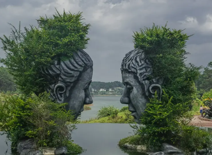 Clay sculptures standing beside water at Sculpture Tunnel in Da Lat