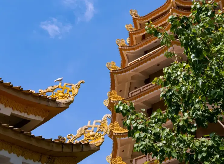 Traditional temple roofs of Vinh Nghiem Pagoda against a blue sky in Ho Chi Minh City