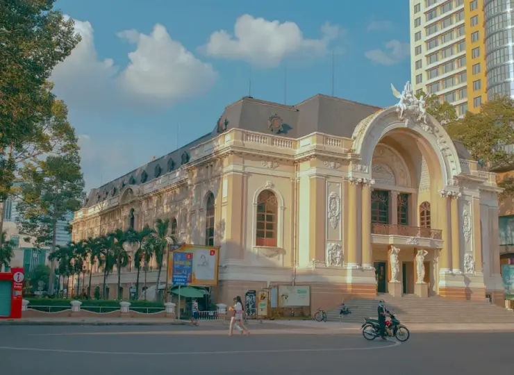 Black car parked near the white Saigon Opera House building in Ho Chi Minh City