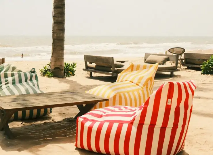 Striped beanbag chairs on a sandy beach near the ocean