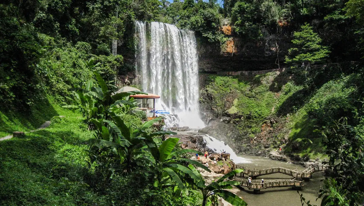 A full waterfall flowing through green forest near Da Lat