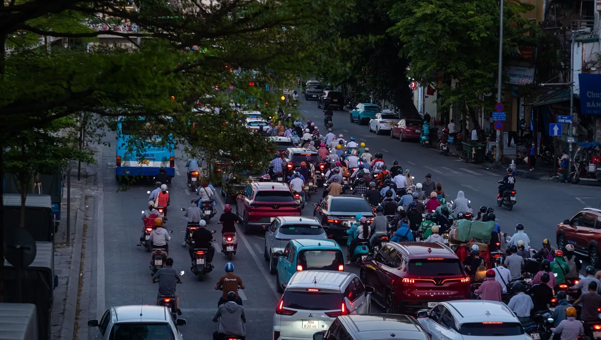 Motorbikes filtering past cars stuck in traffic on a Ho Chi Minh City street