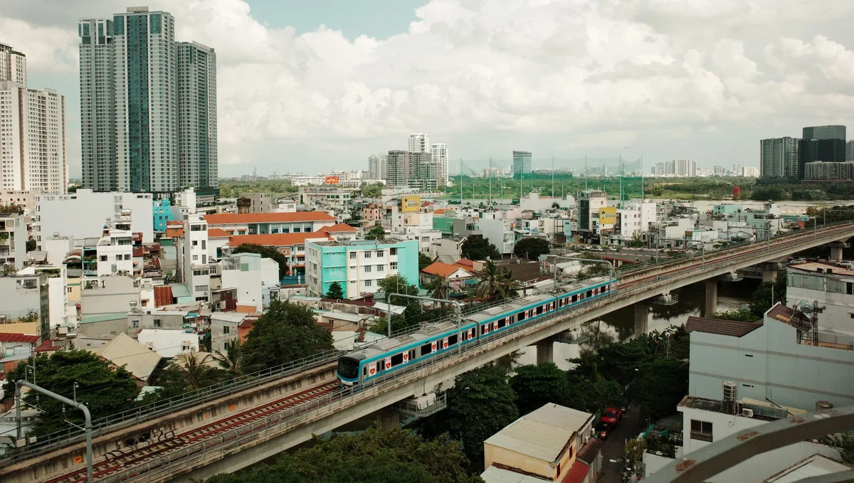 Metro Line 1 train on the elevated viaduct above the rooftops of Ho Chi Minh City