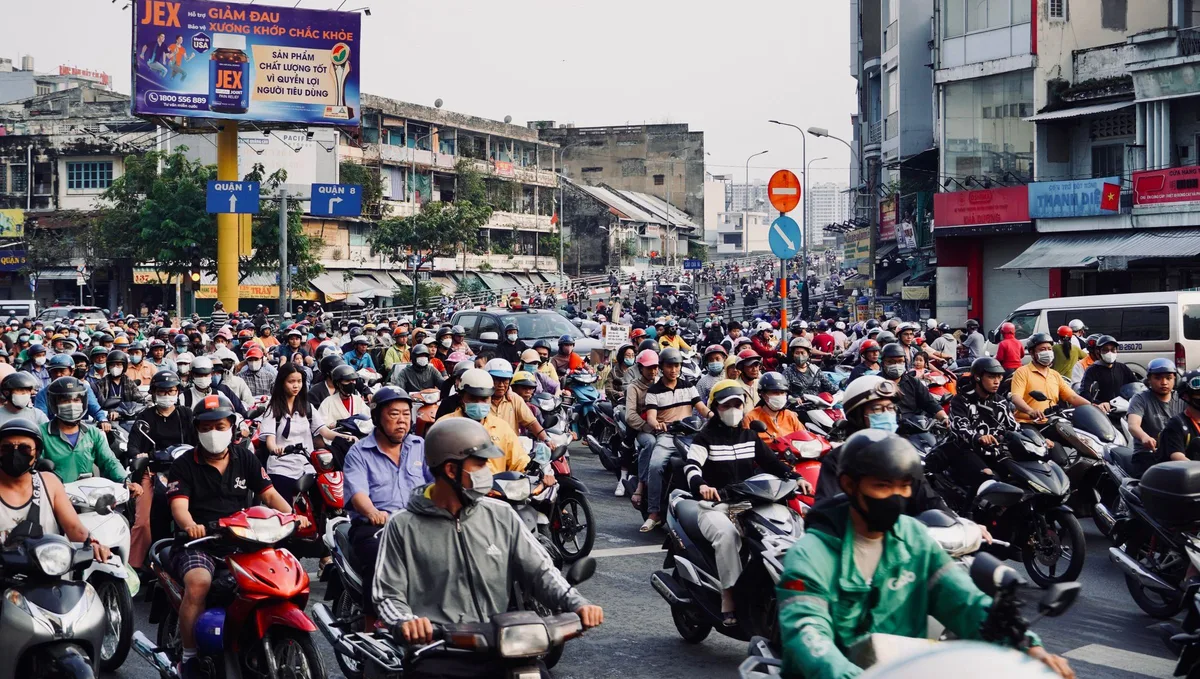 Crowd of motorbikes filling a Ho Chi Minh City junction at rush hour