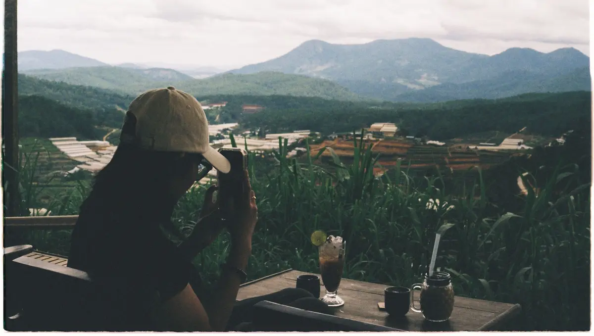 Traveler enjoying drinks at a cafe overlooking the hills of Da Lat