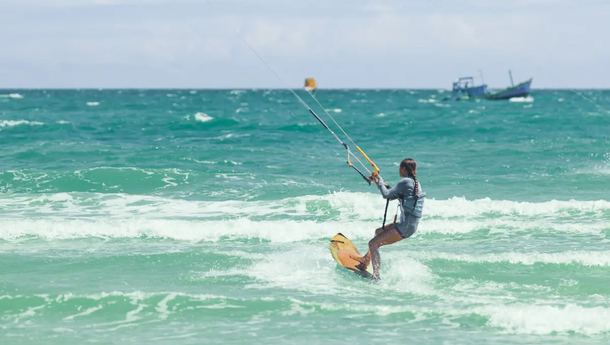 Kitesurfer riding across the turquoise water off Mui Ne