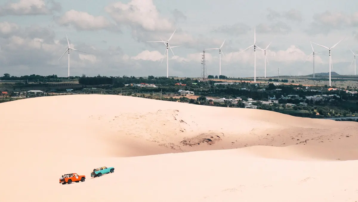 Sand dunes and off-road vehicles near wind turbines in Mui Ne