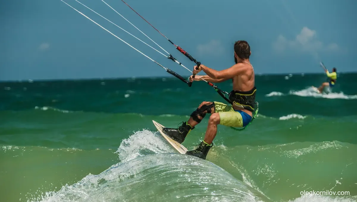 Kitesurfer riding over a small wave in open water